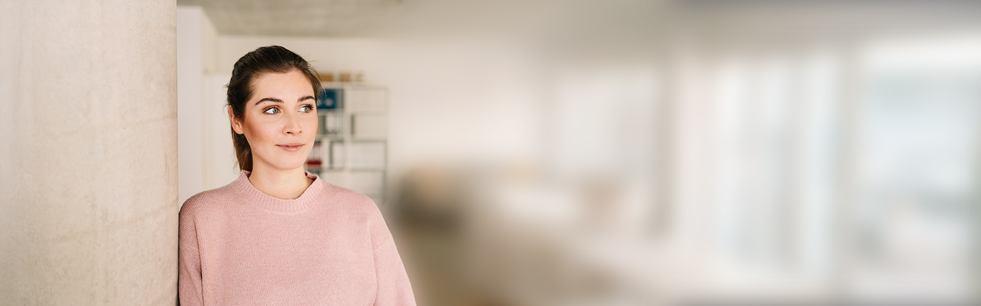 eine Frau, die vor einer Wand steht