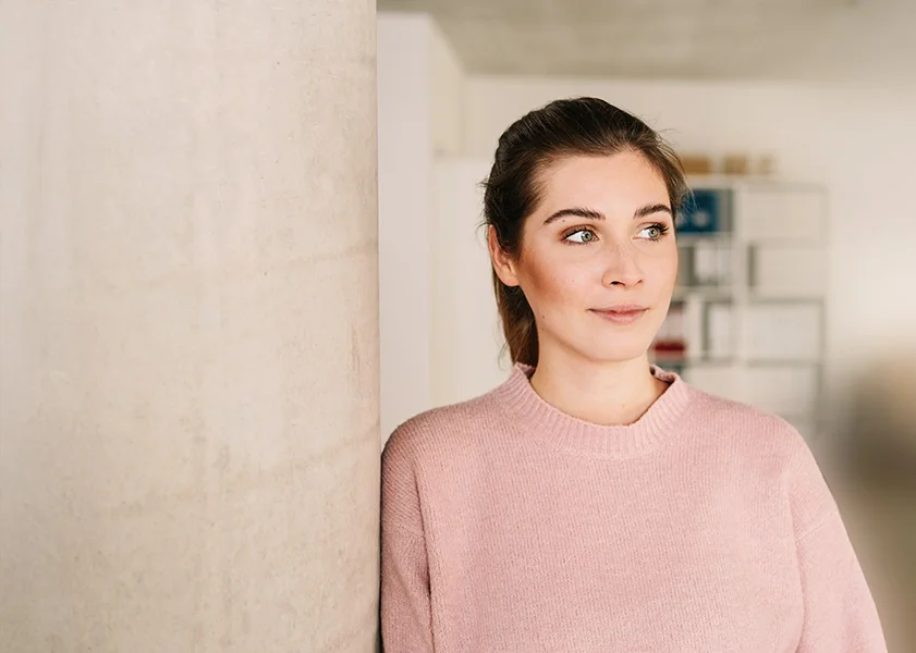 eine Frau, die vor einer Wand steht